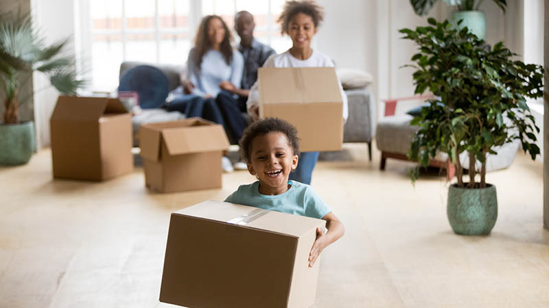 Family with boxes moving into a new house after booking home inspection services