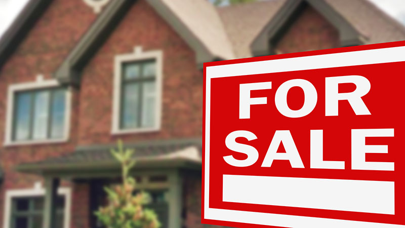 For sale sign in front of a house before home inspection services are scheduled 